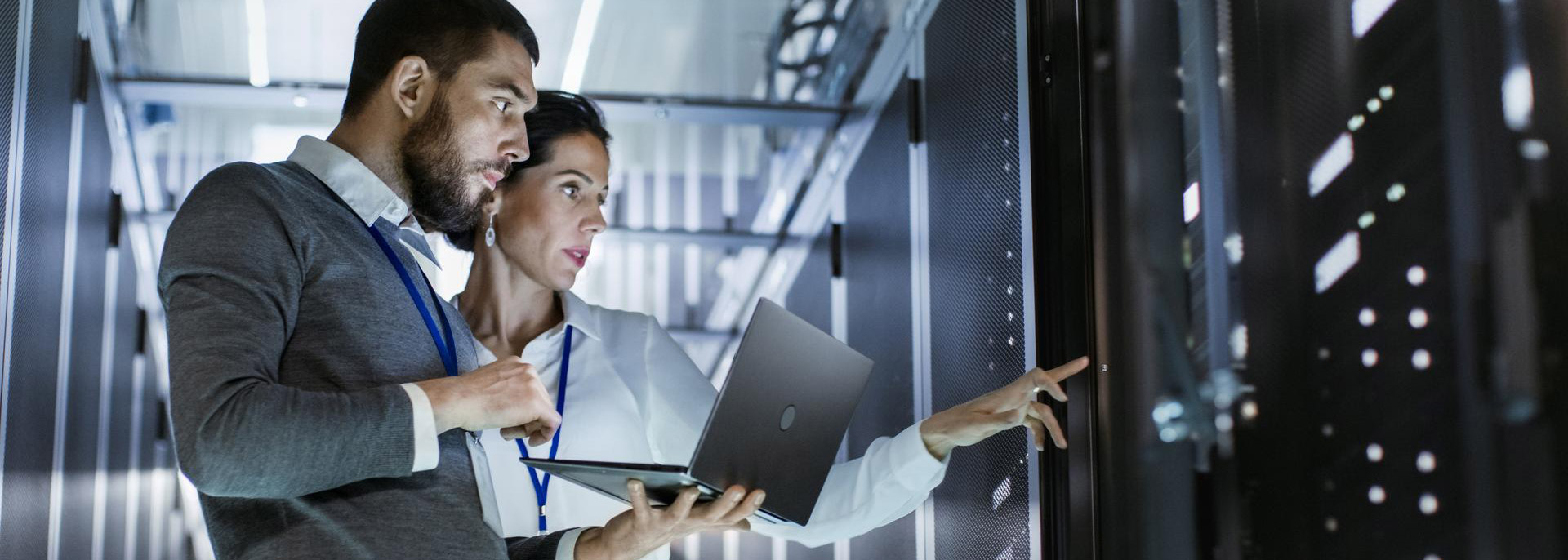 Two people on a computer pointing at a secure hosting server